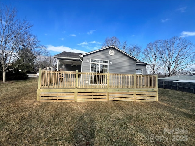 back of house with a wooden deck and a lawn