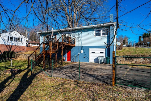 back of house with a deck and a garage