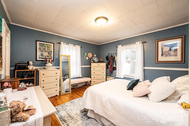 bedroom with light wood-type flooring and ornamental molding