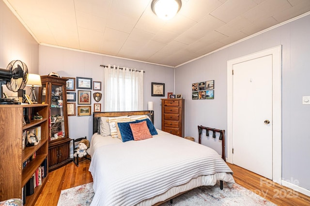 bedroom with crown molding and light hardwood / wood-style floors