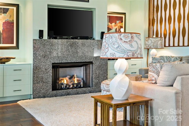 living room with dark wood-type flooring and a high end fireplace