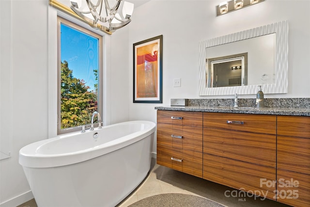 bathroom with vanity, tile patterned floors, a tub, and a notable chandelier