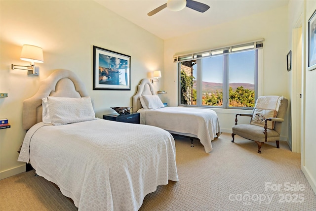 carpeted bedroom with ceiling fan and a mountain view