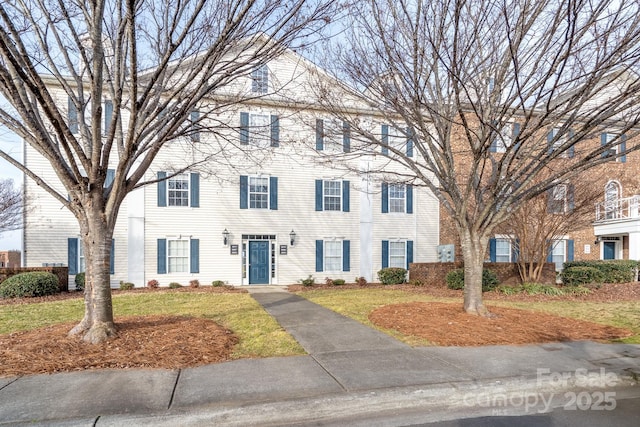 colonial inspired home with a front lawn