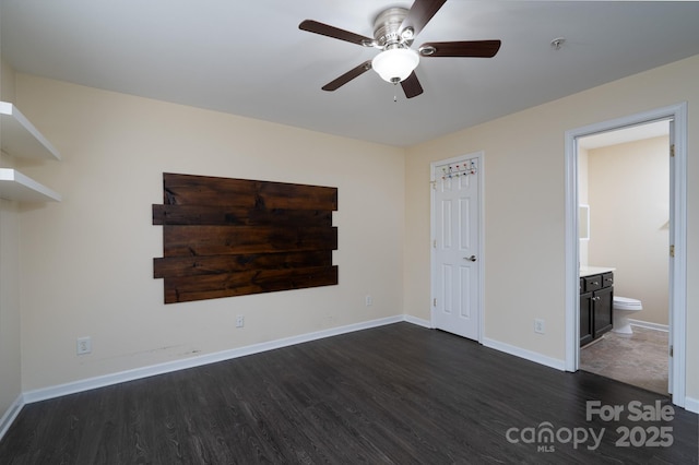 unfurnished bedroom featuring dark hardwood / wood-style flooring, connected bathroom, and ceiling fan