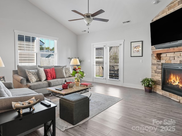 living room with lofted ceiling, hardwood / wood-style floors, a fireplace, and ceiling fan