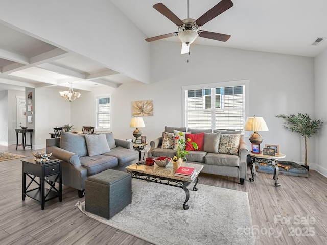 living room featuring beam ceiling, a wealth of natural light, light hardwood / wood-style flooring, and ceiling fan with notable chandelier