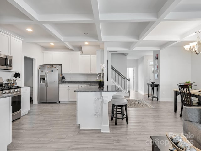 kitchen featuring appliances with stainless steel finishes, dark stone counters, and white cabinets