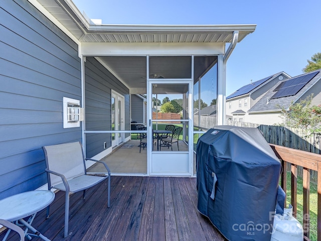 wooden deck with grilling area and a sunroom