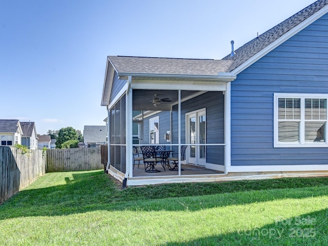 back of house with ceiling fan, a sunroom, a patio, and a lawn