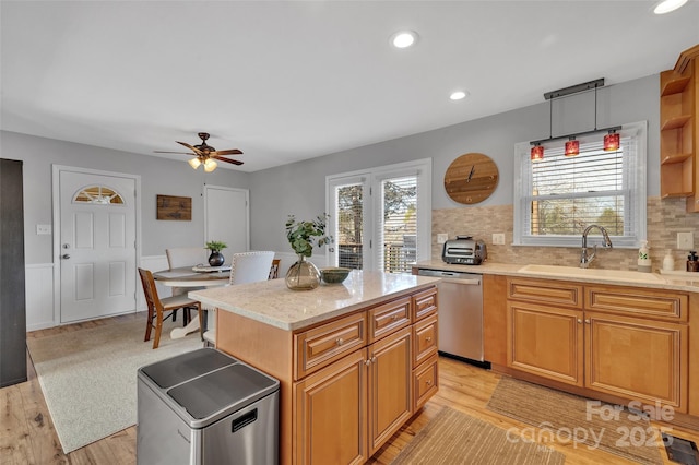 kitchen featuring a center island, decorative backsplash, sink, hanging light fixtures, and stainless steel dishwasher