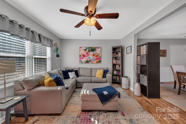 living room with ceiling fan and light wood-type flooring