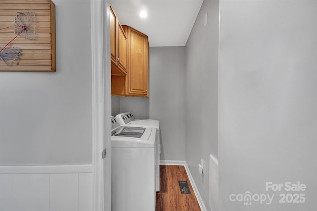 laundry room featuring cabinets, independent washer and dryer, and dark hardwood / wood-style floors