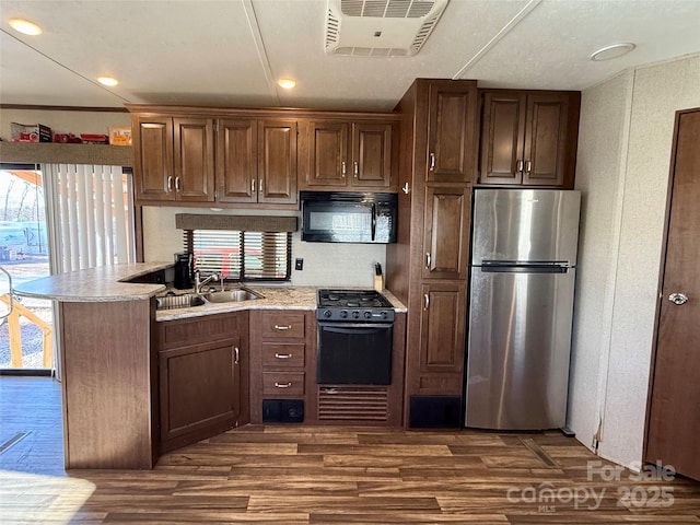 kitchen with black appliances, dark hardwood / wood-style flooring, sink, kitchen peninsula, and crown molding