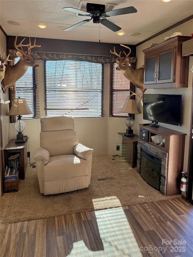 living room featuring hardwood / wood-style flooring, ornamental molding, and ceiling fan