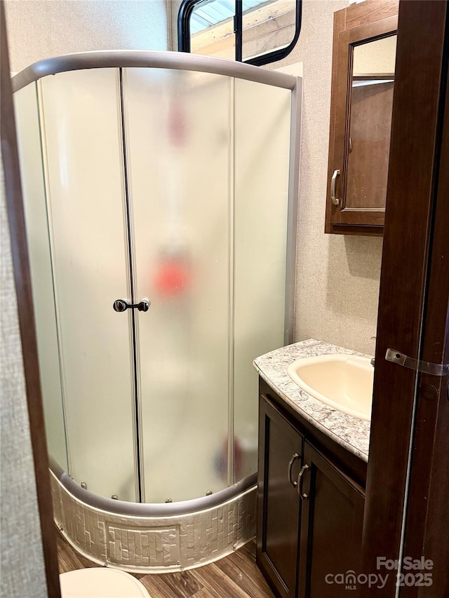 bathroom featuring vanity, hardwood / wood-style floors, and an enclosed shower