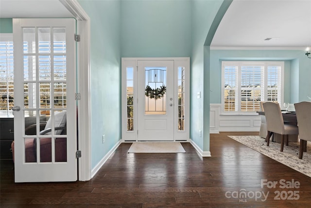 foyer with dark hardwood / wood-style flooring and crown molding