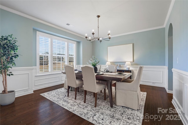 dining space with crown molding, dark hardwood / wood-style floors, and a notable chandelier