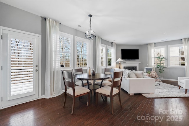 dining area with dark wood-type flooring and a notable chandelier