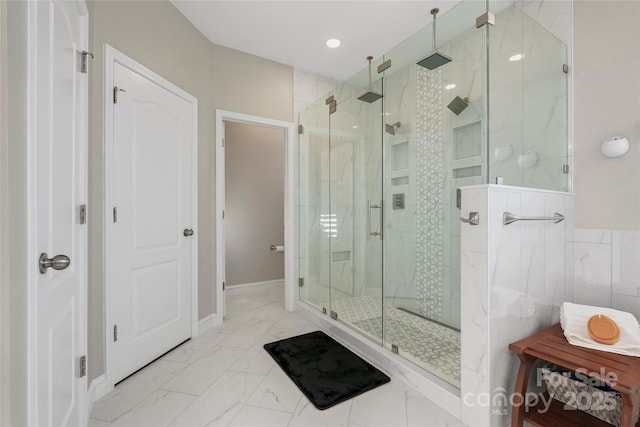 bathroom featuring marble finish floor and a stall shower