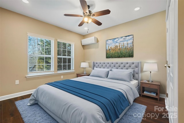 bedroom featuring dark wood finished floors, an AC wall unit, and baseboards