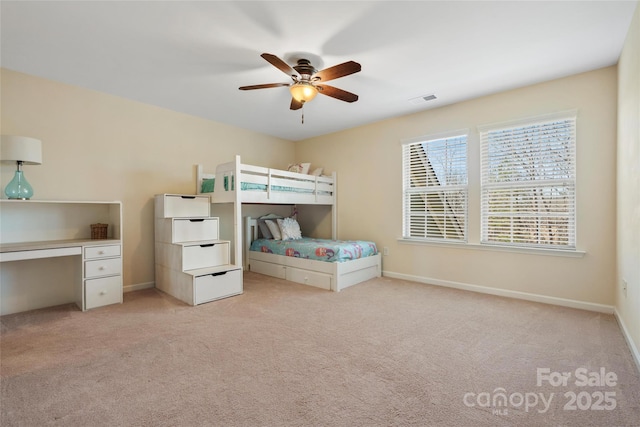 unfurnished bedroom with visible vents, light colored carpet, baseboards, and ceiling fan