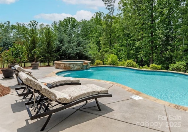 view of swimming pool featuring a patio area, a pool with connected hot tub, and fence