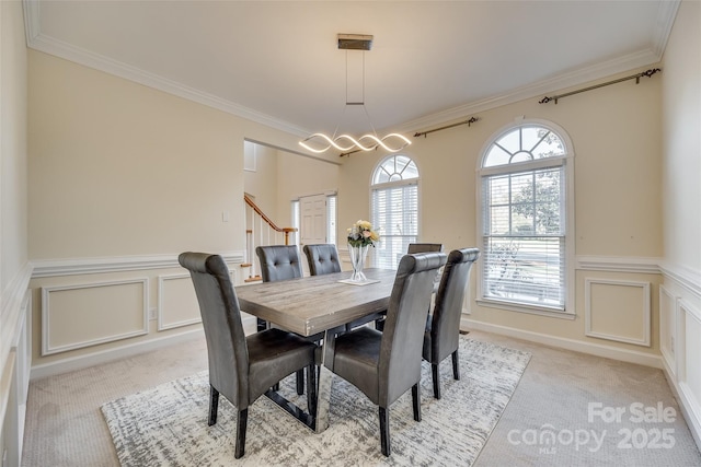 carpeted dining space featuring ornamental molding and a chandelier