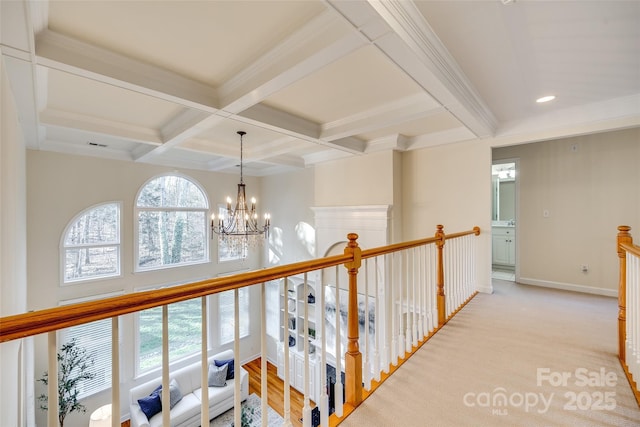 hall featuring beam ceiling, light colored carpet, coffered ceiling, and a chandelier