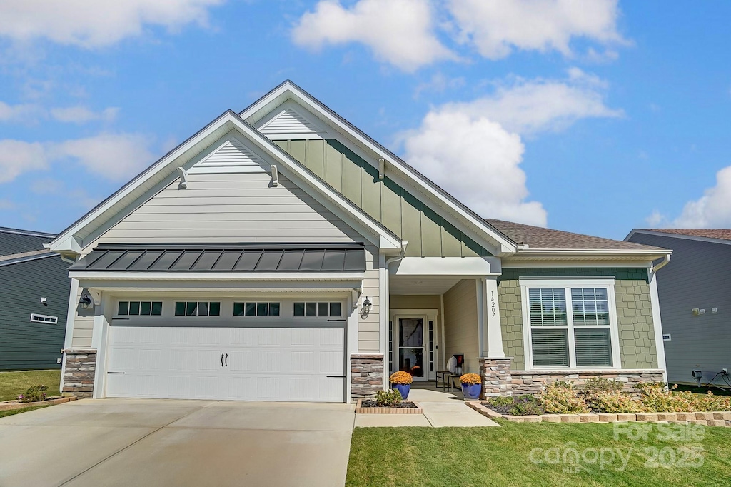 craftsman-style home with a garage and a front lawn