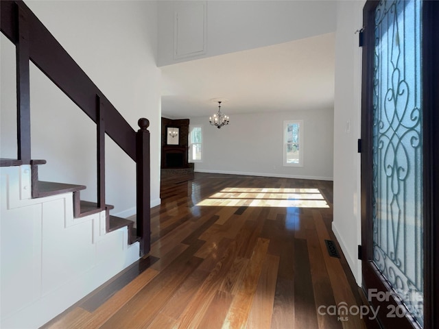 entrance foyer featuring an inviting chandelier and dark hardwood / wood-style flooring