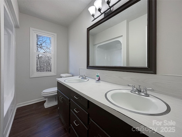 bathroom featuring toilet, vanity, a textured ceiling, and hardwood / wood-style flooring