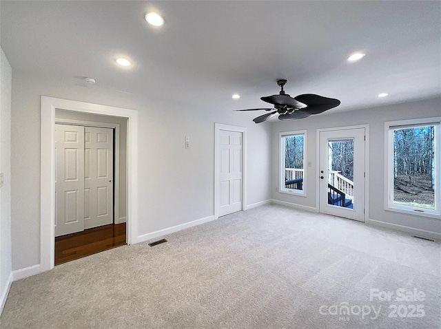 interior space with ceiling fan and light colored carpet