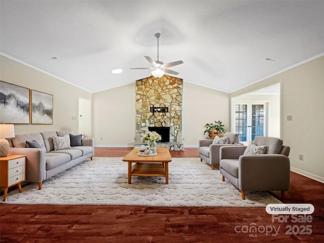 living room with hardwood / wood-style floors, vaulted ceiling, ornamental molding, ceiling fan, and a fireplace