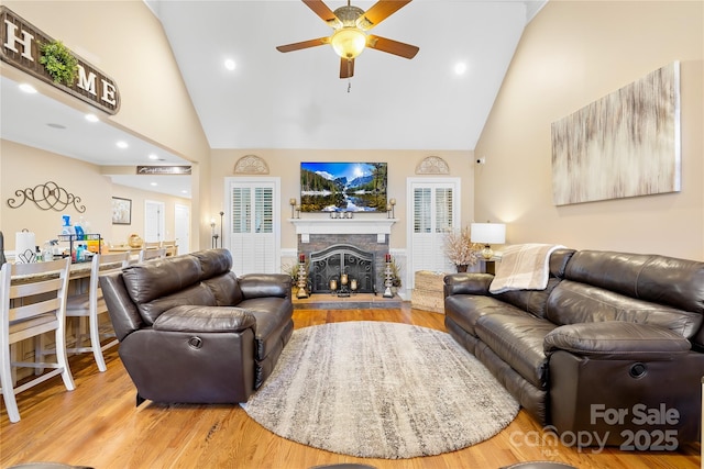 living room featuring wood finished floors, high vaulted ceiling, a fireplace, recessed lighting, and ceiling fan