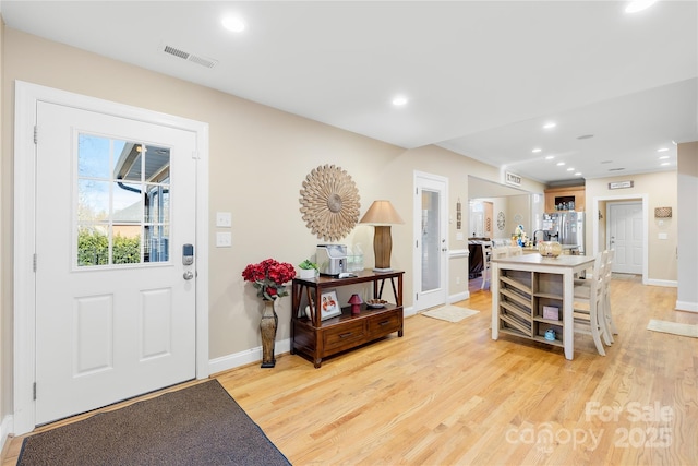 foyer with recessed lighting, visible vents, baseboards, and light wood finished floors