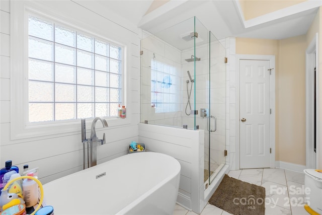 full bathroom with a freestanding tub, baseboards, marble finish floor, and a shower stall