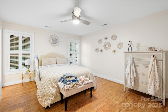 bedroom featuring a ceiling fan, baseboards, visible vents, and light wood-type flooring