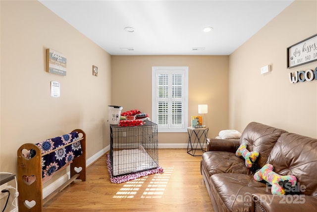 living area featuring visible vents, baseboards, and wood finished floors