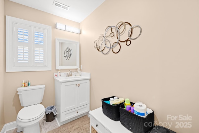 bathroom featuring vanity, toilet, baseboards, and visible vents