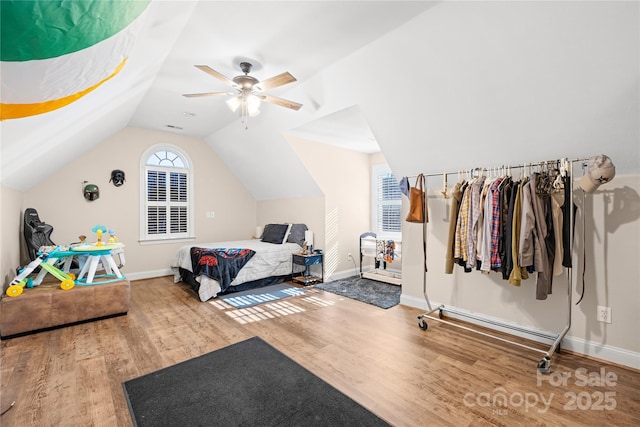 bedroom featuring ceiling fan, baseboards, lofted ceiling, and wood finished floors