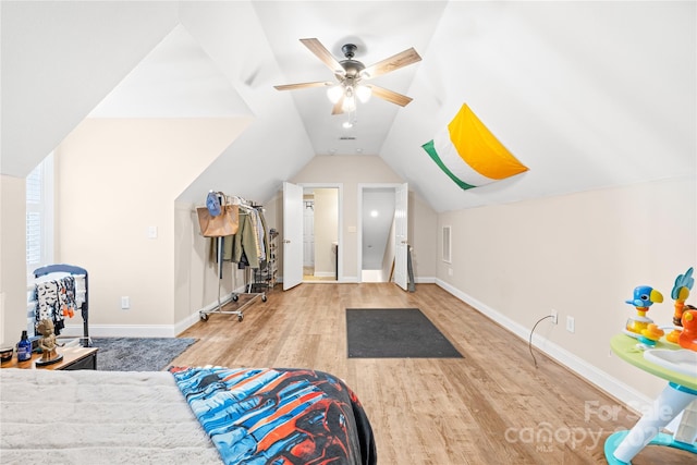 bedroom with ceiling fan, baseboards, wood finished floors, and vaulted ceiling