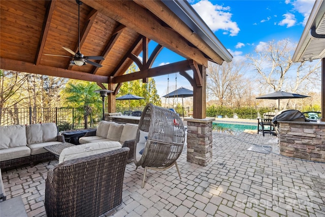 view of patio / terrace with a ceiling fan, a gazebo, exterior kitchen, a fenced in pool, and an outdoor hangout area