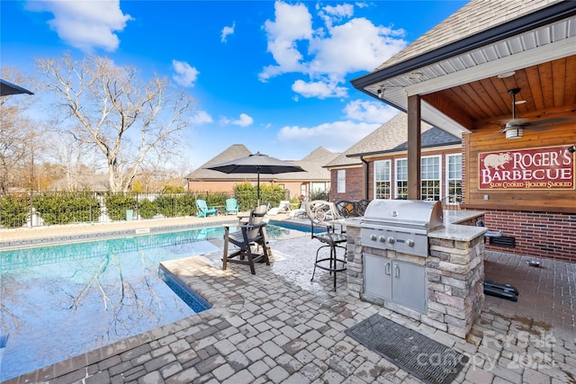 exterior space featuring a fenced in pool, fence, exterior kitchen, a grill, and a patio