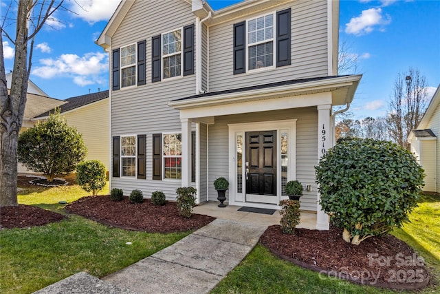 view of property with a front lawn and covered porch