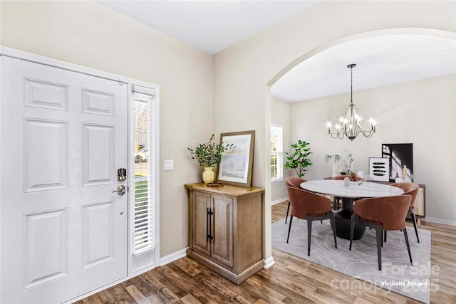 entryway with a chandelier, a healthy amount of sunlight, and wood-type flooring