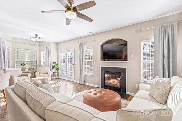 living room with ceiling fan and dark hardwood / wood-style flooring