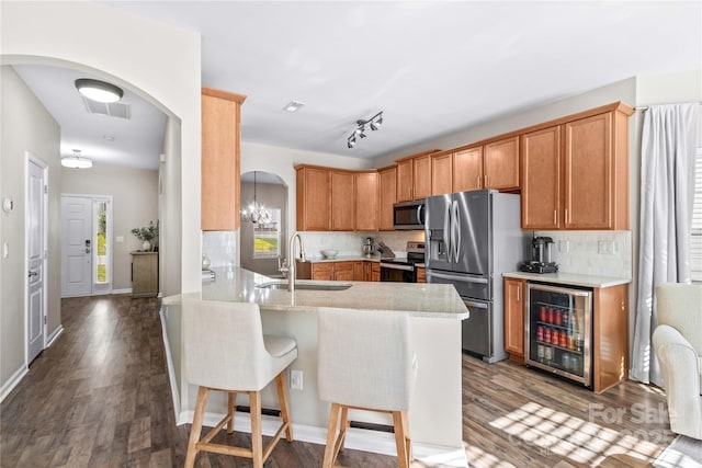 kitchen featuring wine cooler, kitchen peninsula, sink, stainless steel appliances, and dark hardwood / wood-style flooring