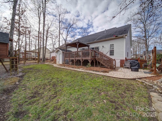 rear view of property with a storage shed, a deck, and a yard