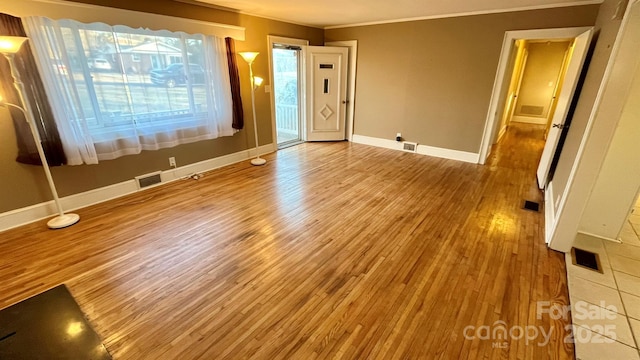 unfurnished room featuring crown molding and light hardwood / wood-style flooring